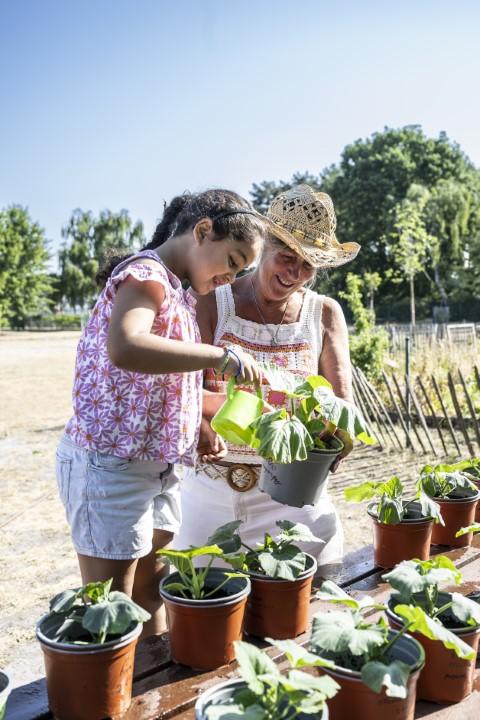 Leerling en leraar geven planten water in De Brem